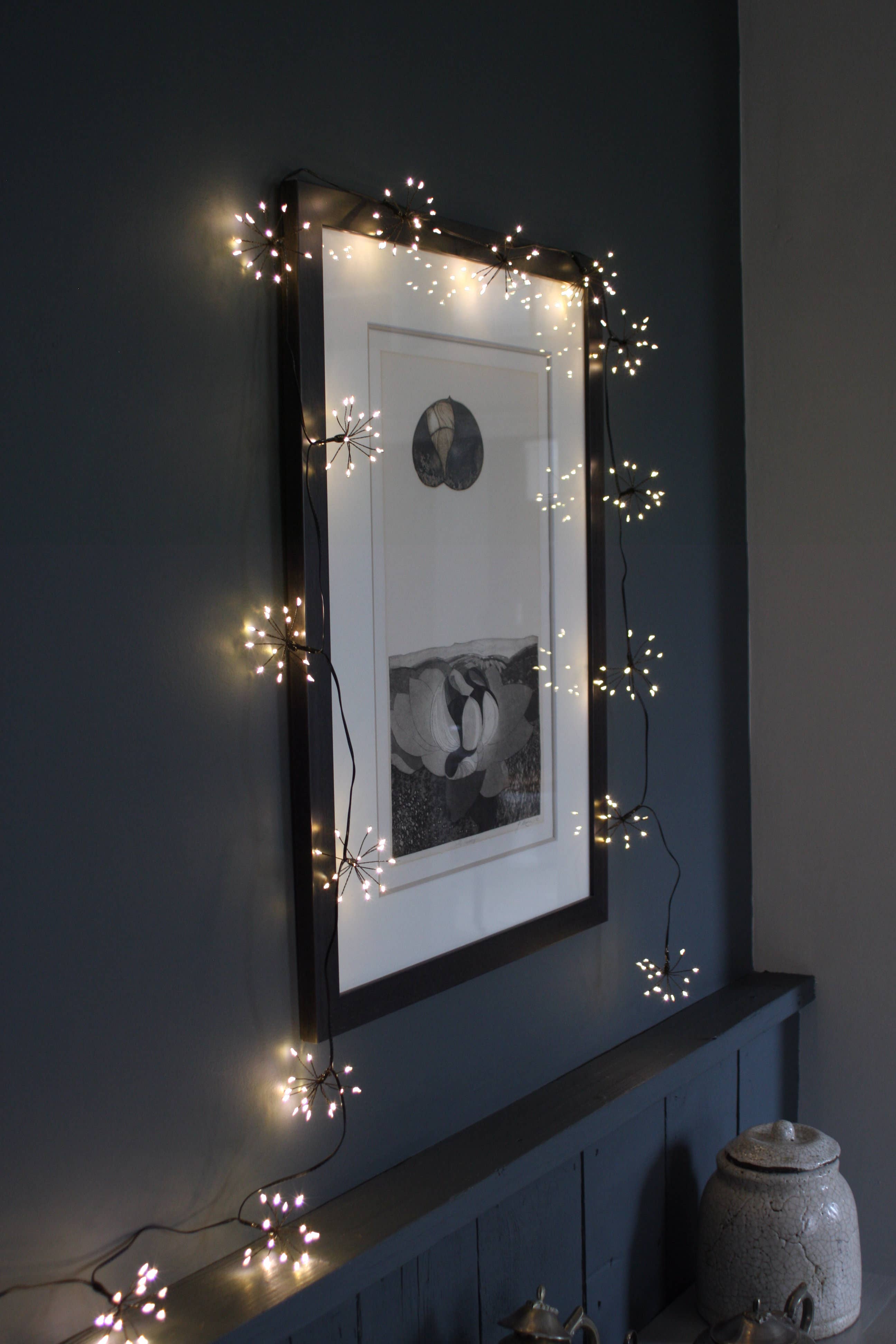 Starburst Chain: Warm white LED fairy lights on black-framed artwork