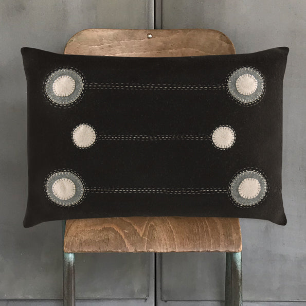 Black wool cushion with embroidered circular ring patches