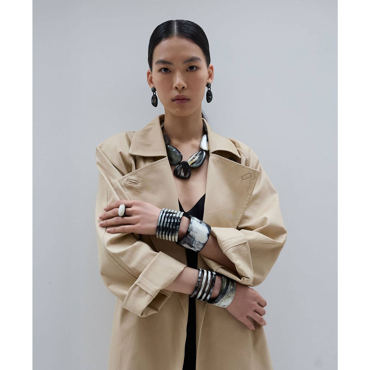 Beige trench coat with structured collar, flap pockets, and horn ring gift