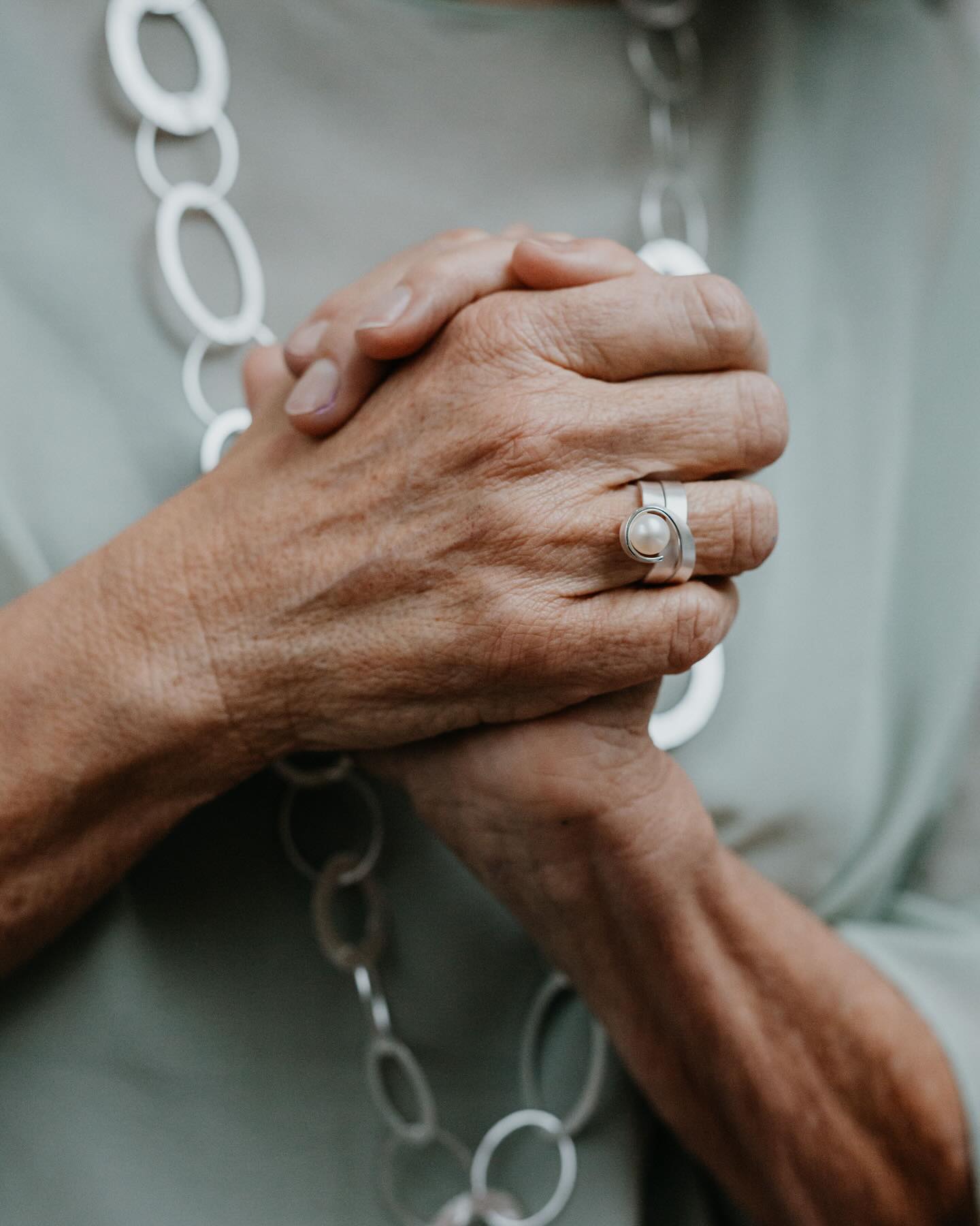 Silver pearl centerpiece ring on elderly finger