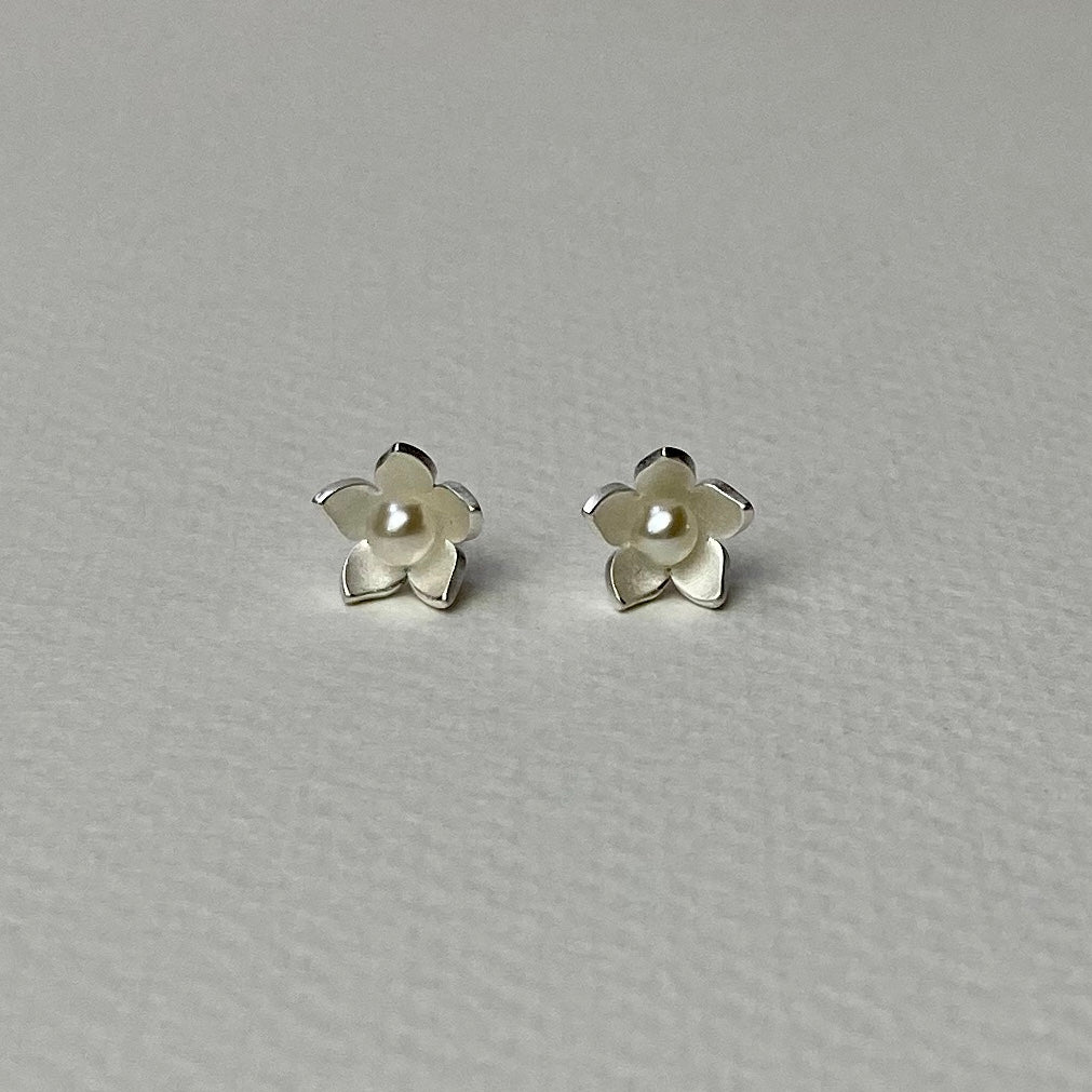 Silver flower-shaped stud earrings with central pearl