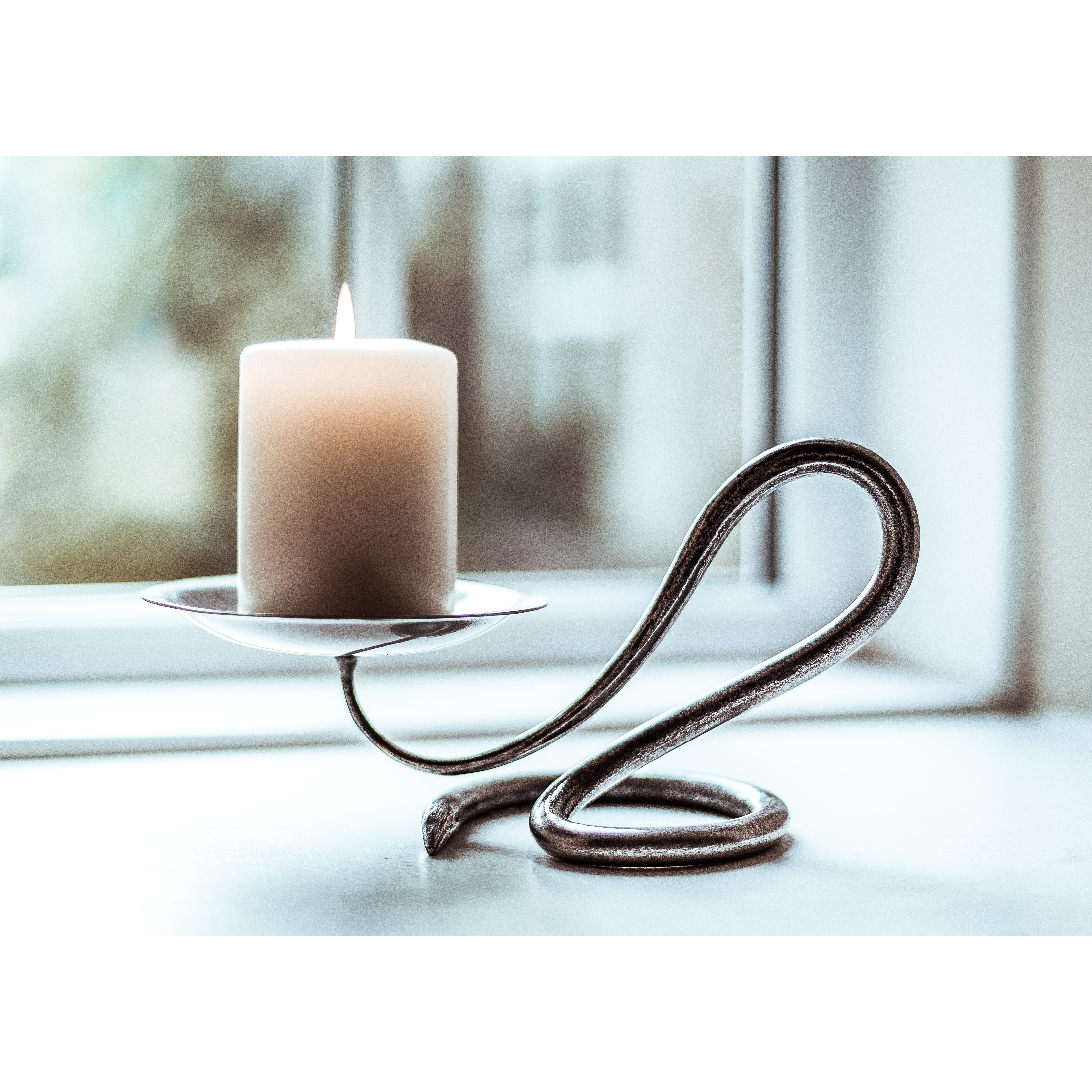 Sleek dark metallic Single Round Candleholder with twisted serpentine design and off-white pillar candle