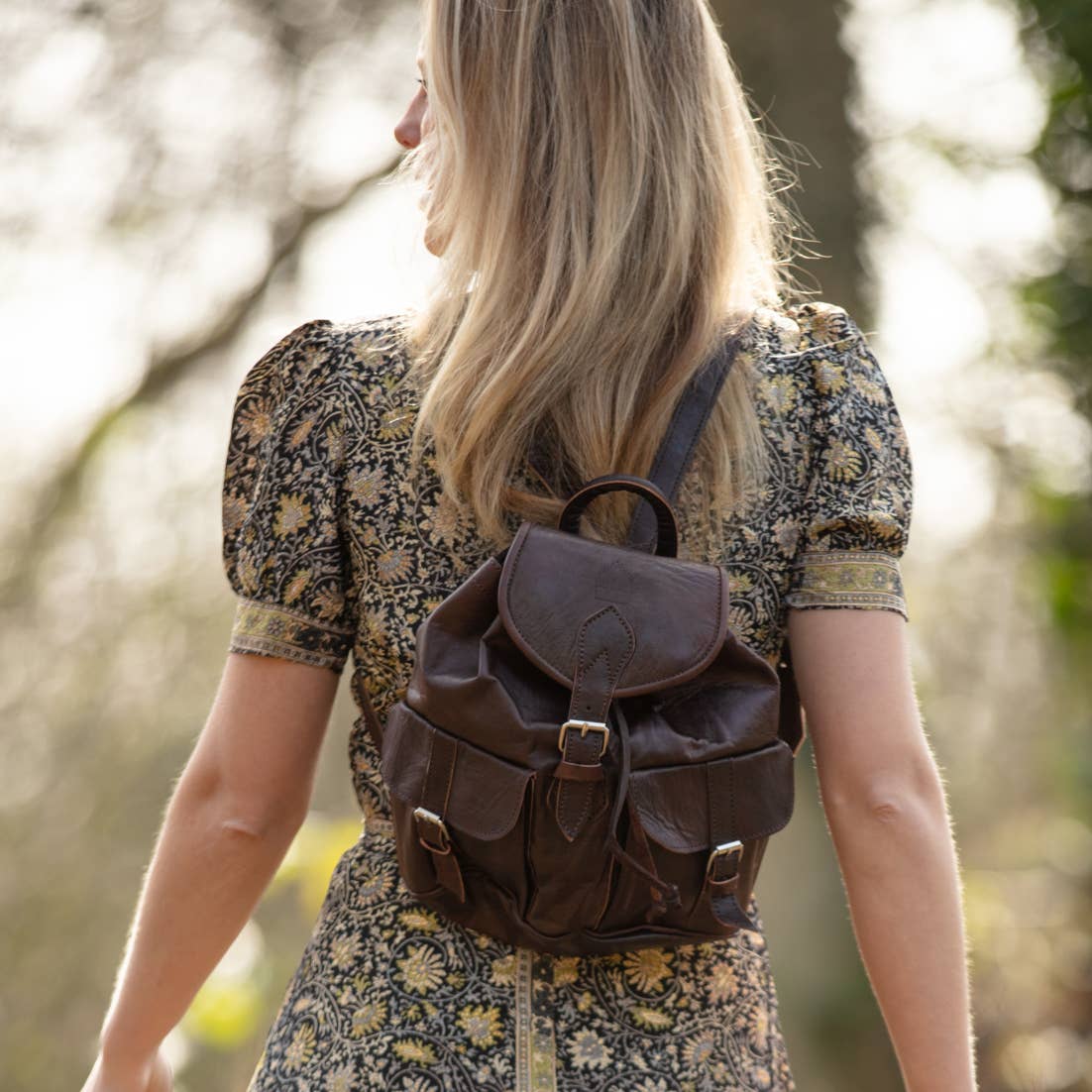 Tan small leather rucksack with brown flap closure and pockets