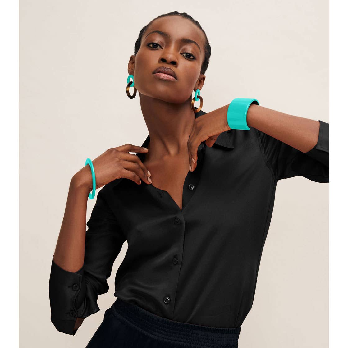 Black satin button-down shirt with rolled cuffs and aquamarine horn earring