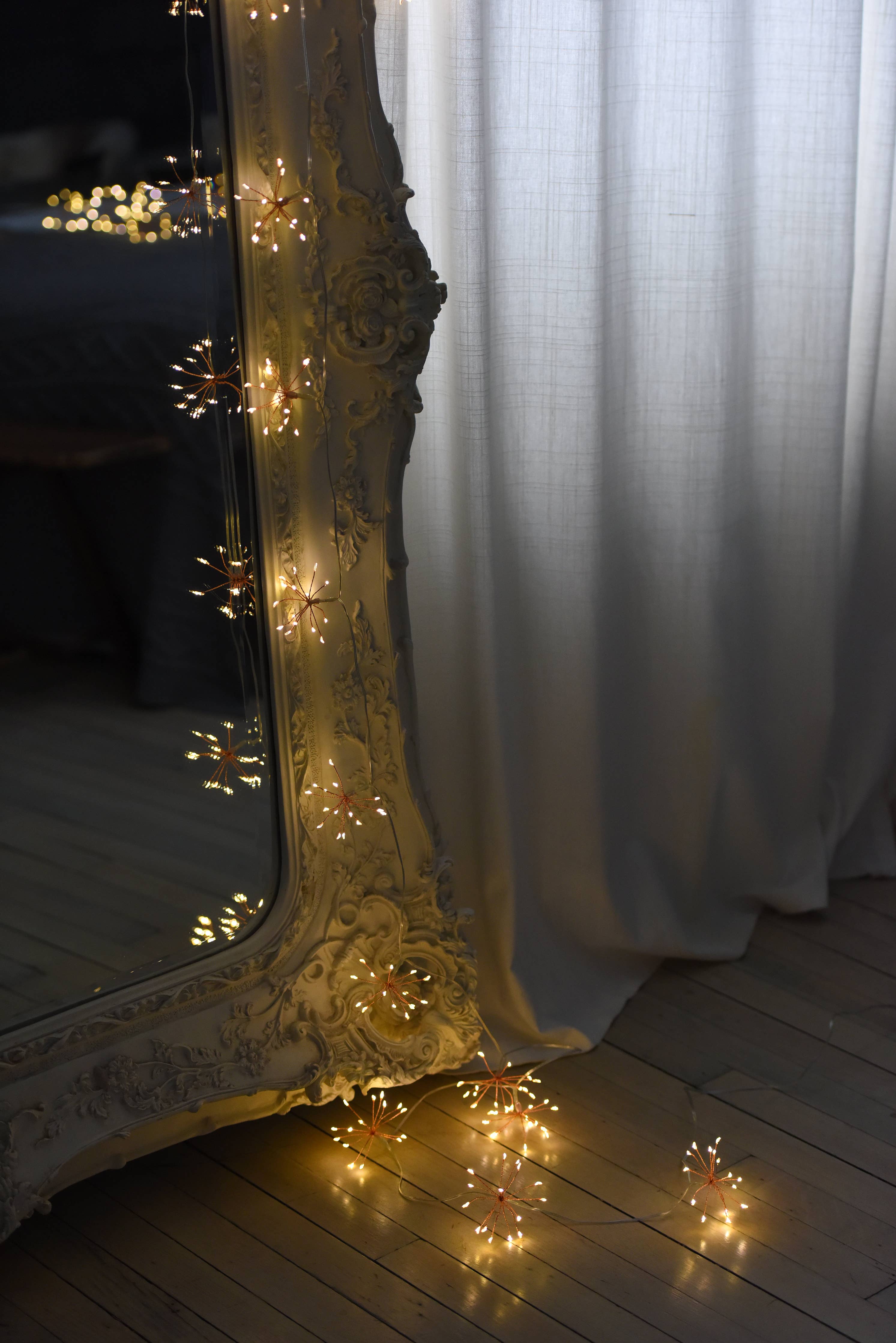 Gold-toned ornate mirror frame with starburst fairy lights in black battery chain