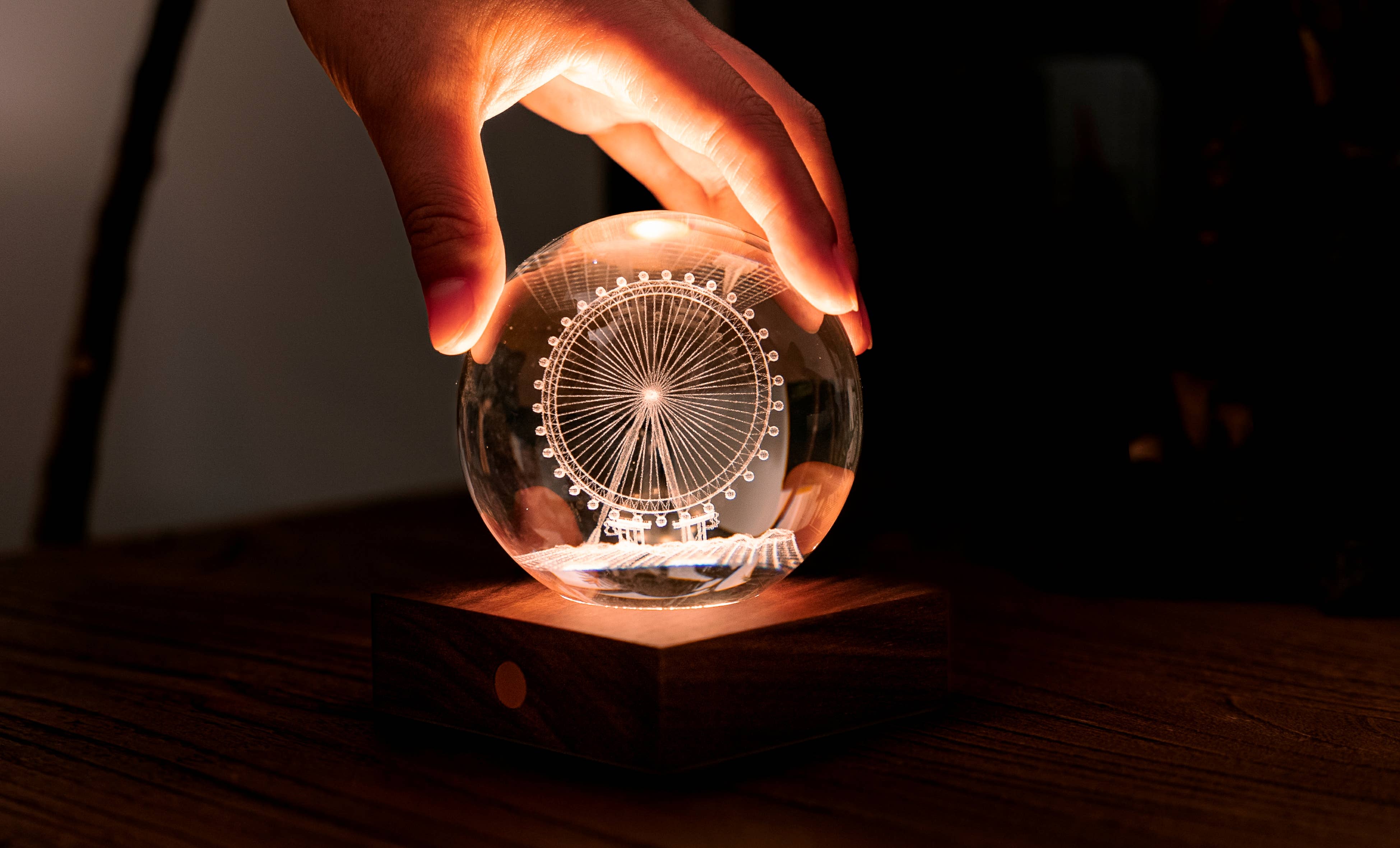 Illuminated amber crystal light sphere with London Eye engraving