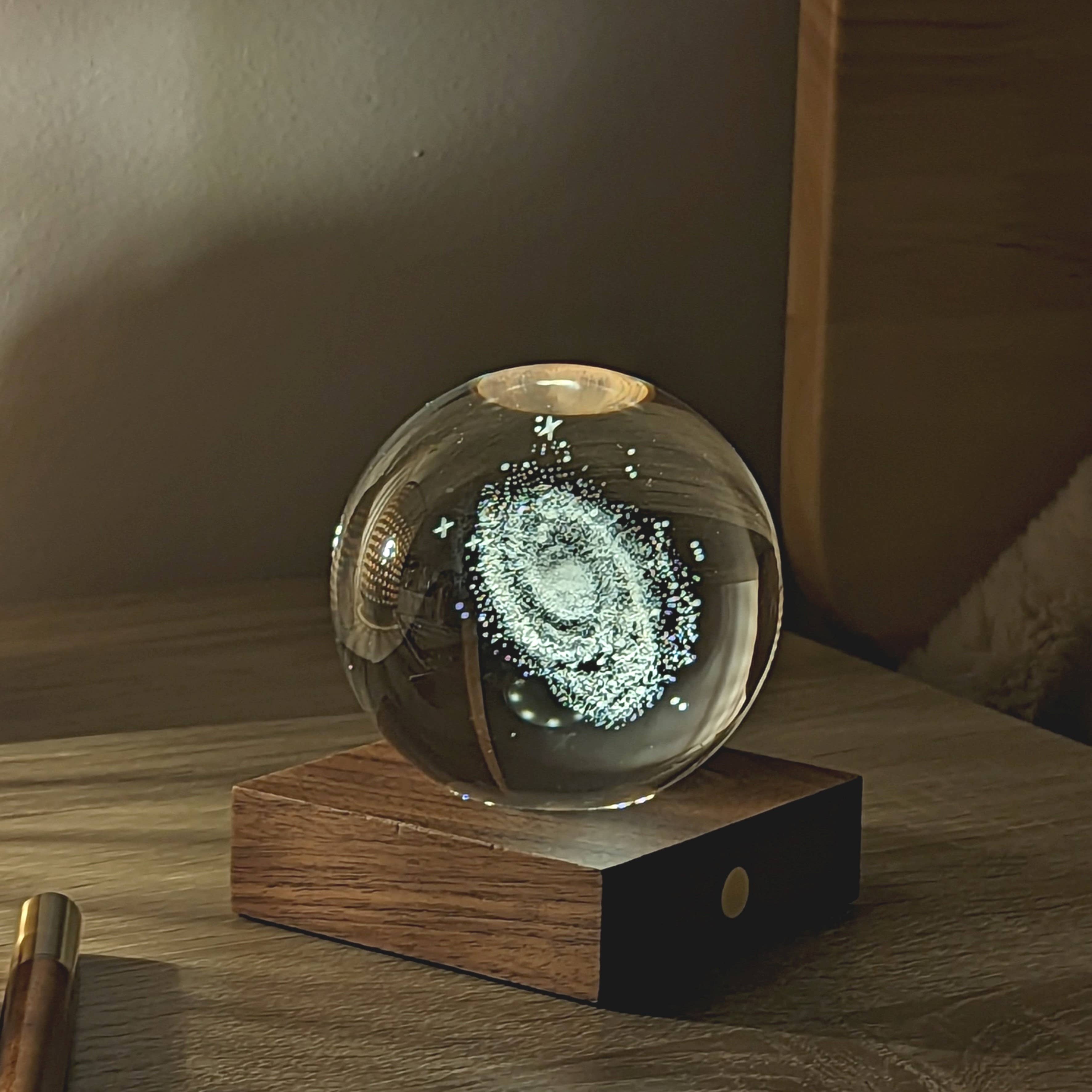 Amber Crystal Light Golf: clear glass sphere with swirling galaxy on wood base