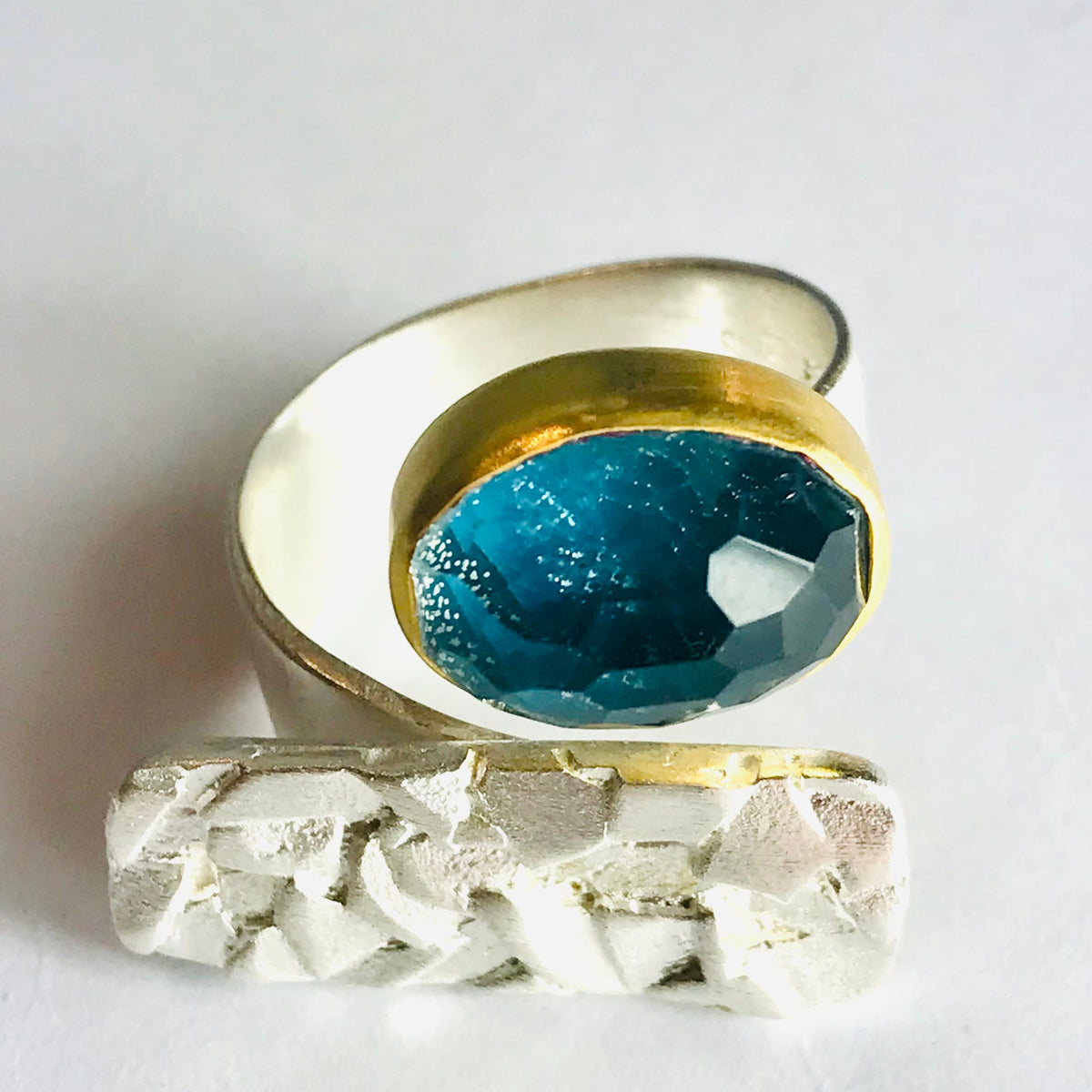 Apatite Ring Blue: faceted teal gem in gold bezel on textured silver band