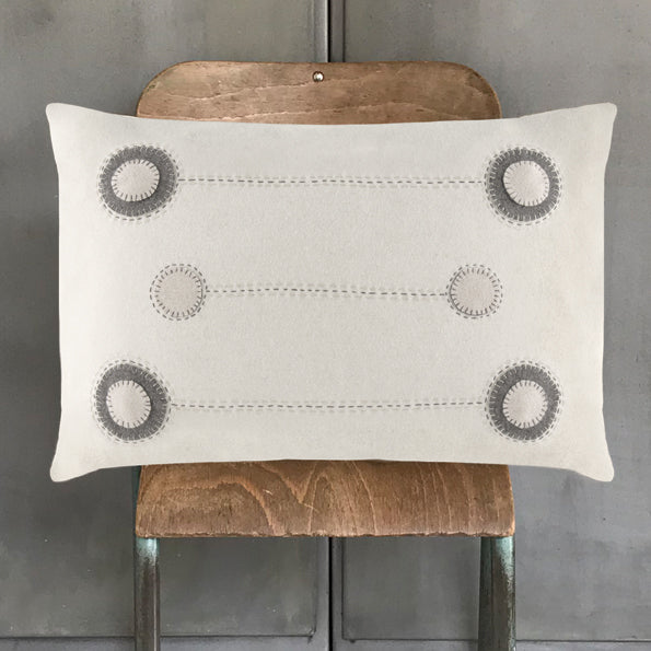 Cream wool cushion with embroidered gray circle rows