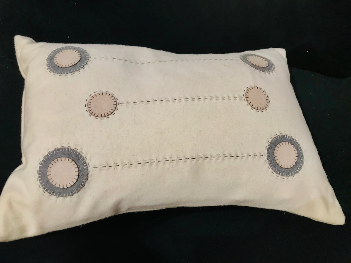 Cream wool cushion with beige and gray embroidered motifs
