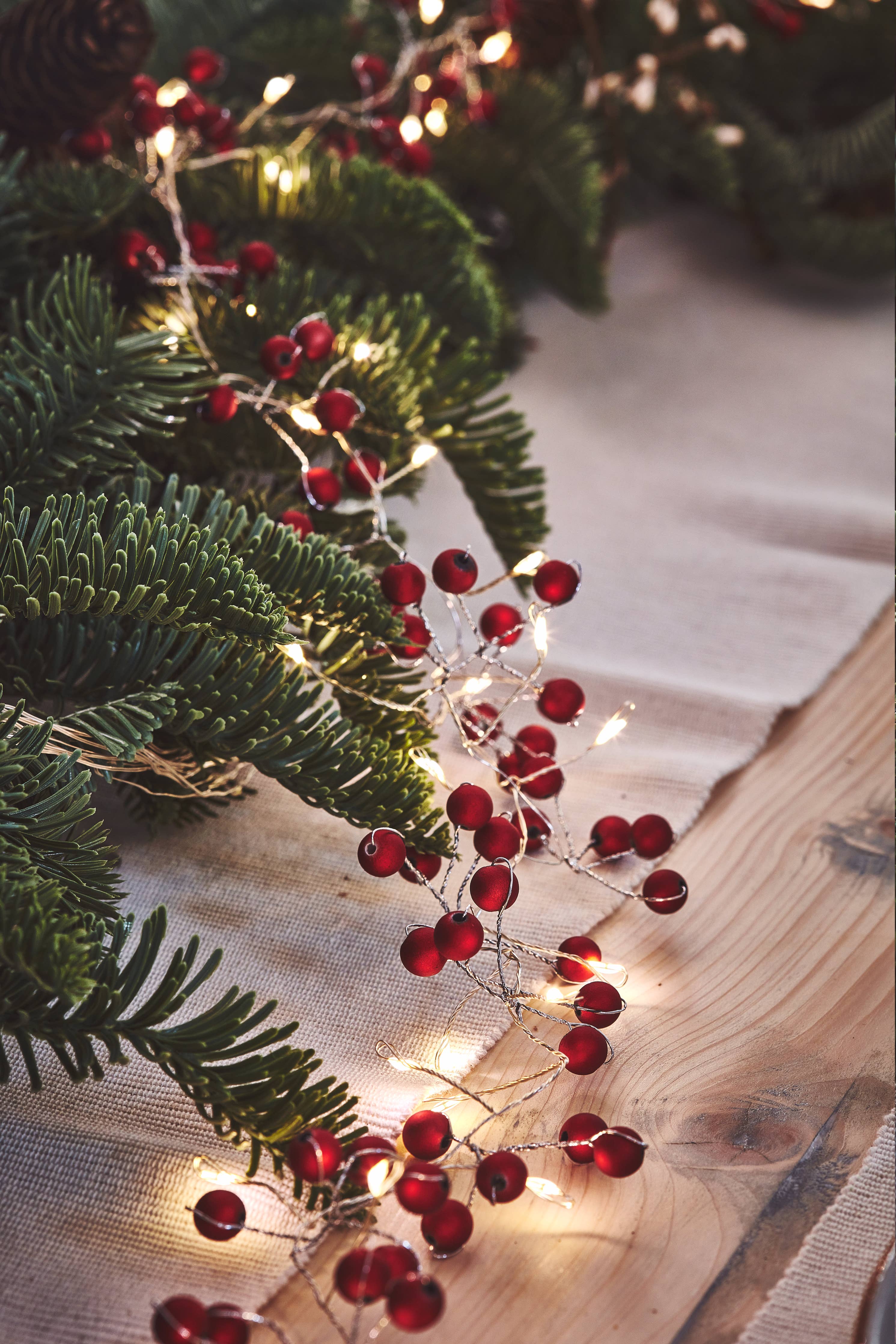 Red Berry Mains: Festive Christmas Lights with Berry Ornaments on Pine