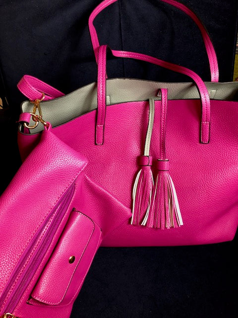 Vibrant fuchsia leather tote bag with gray interior and tassel accents