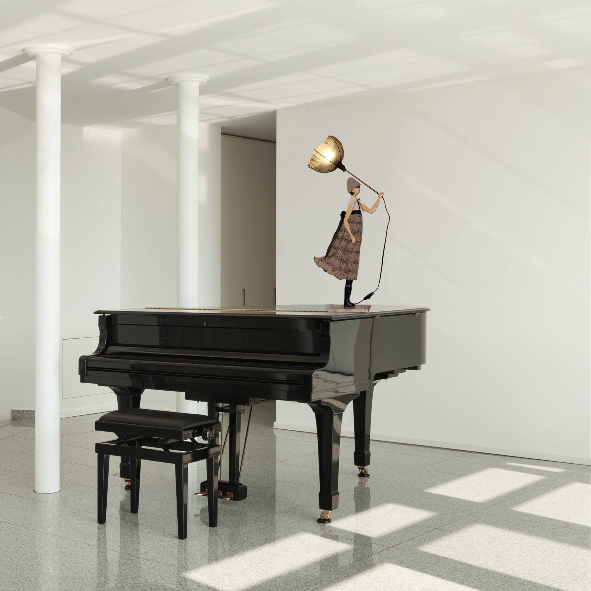 Sleek black grand piano with glossy finish and gold feet in white room