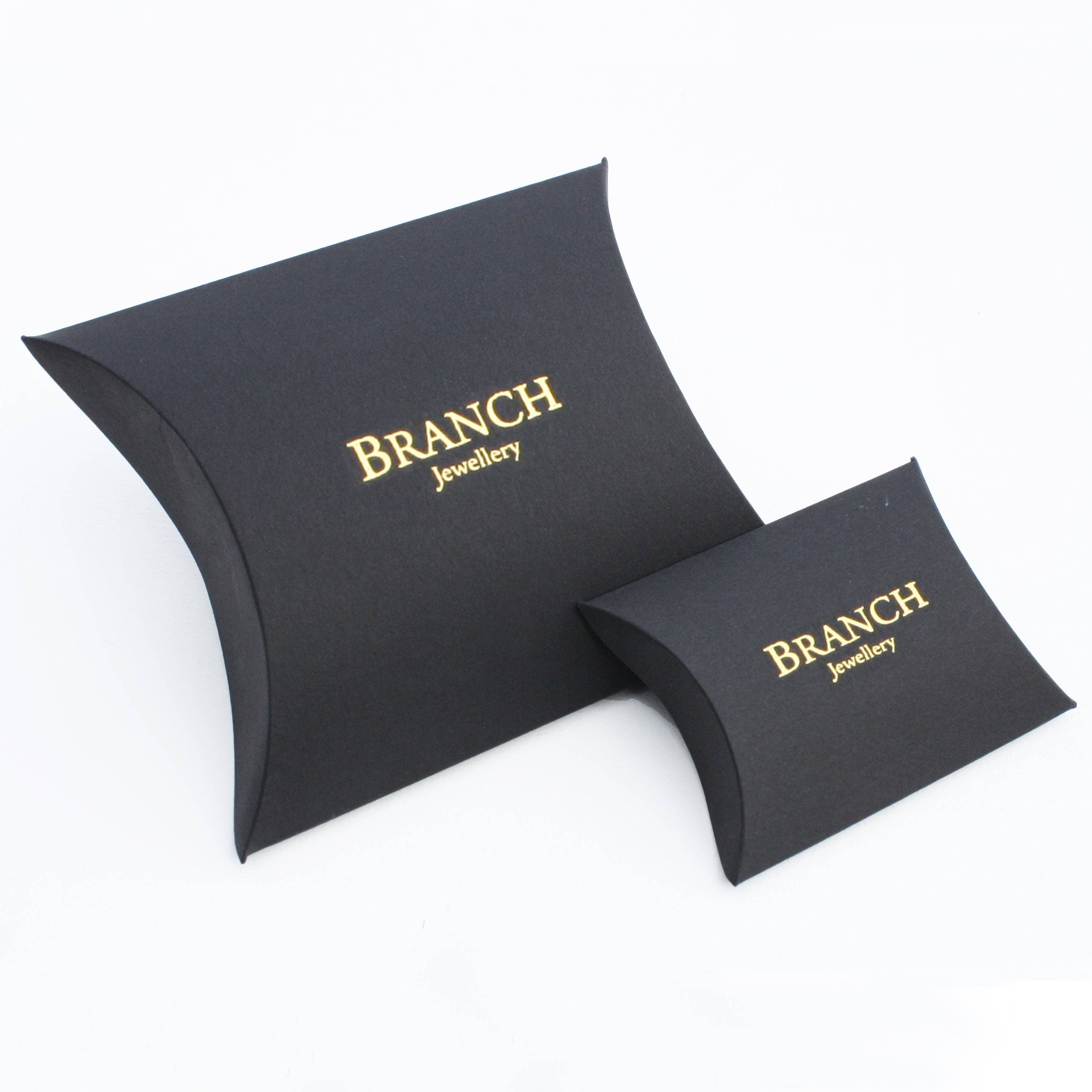 Black pillow-shaped gift boxes with gold foil branch jewellery branding for medium gold and black enamel domed ring