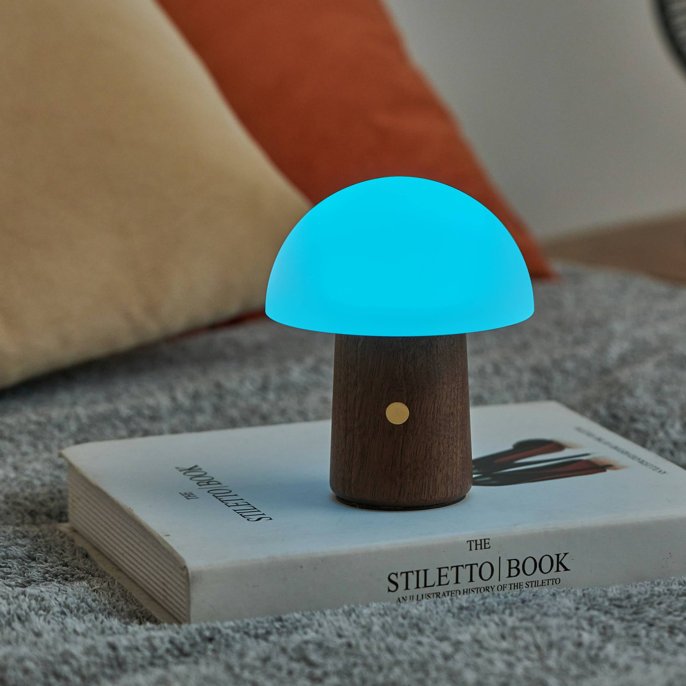 Glowing blue mushroom LED nightlight on walnut wood base with gold accent