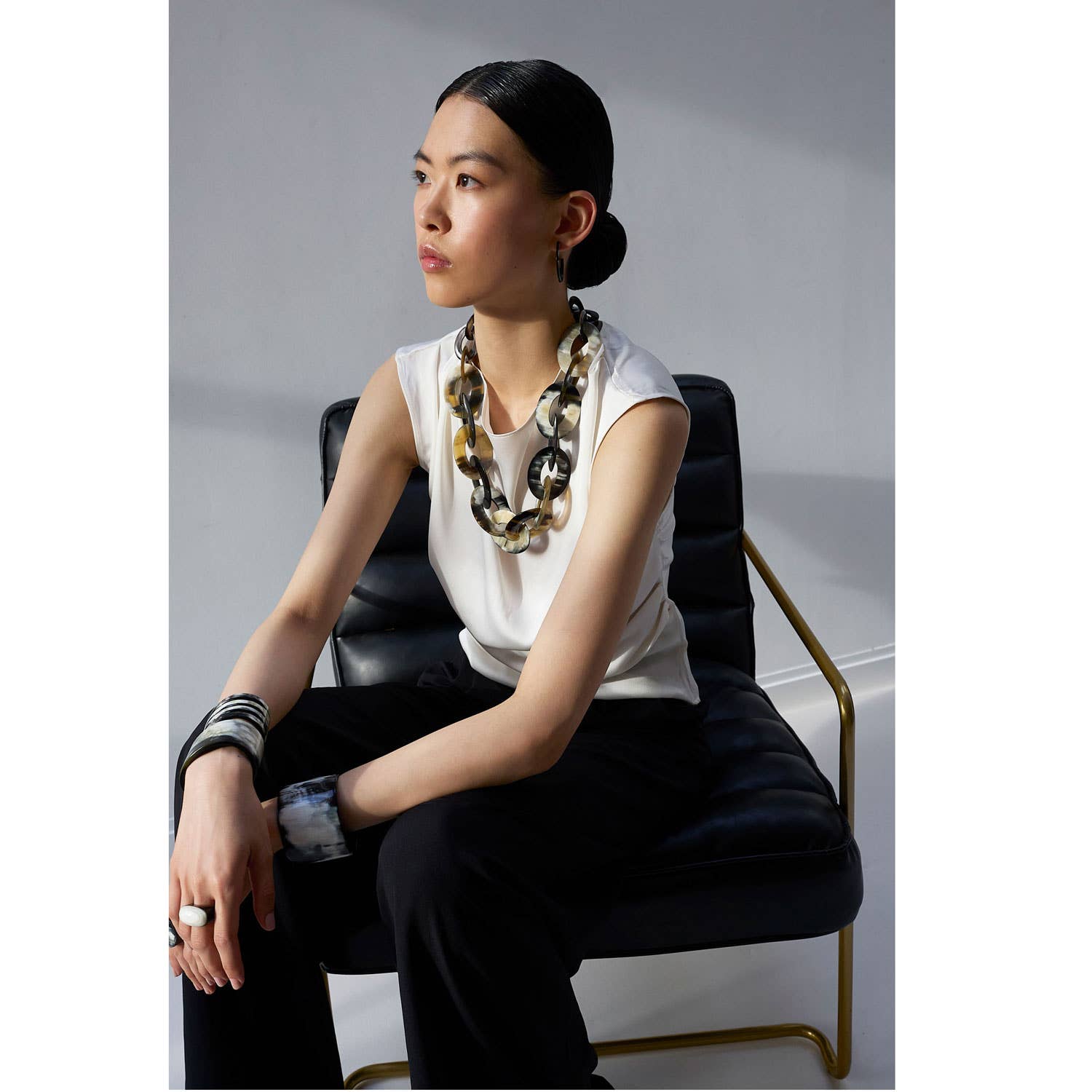 Bold multi-toned oval horn necklace with large interlocking circular links in black, beige, and brown