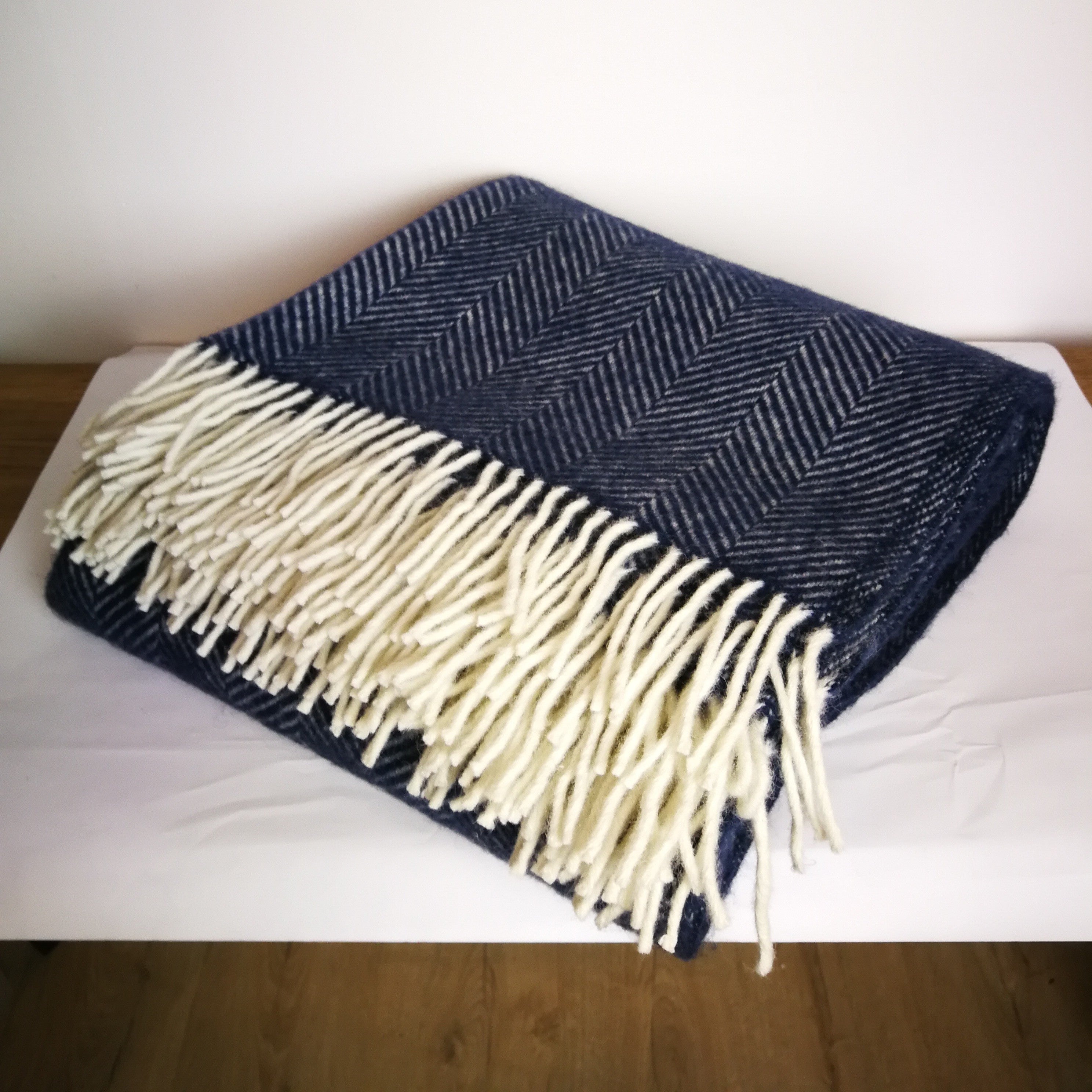 Navy blue and cream herringbone woven throw blanket with fringe