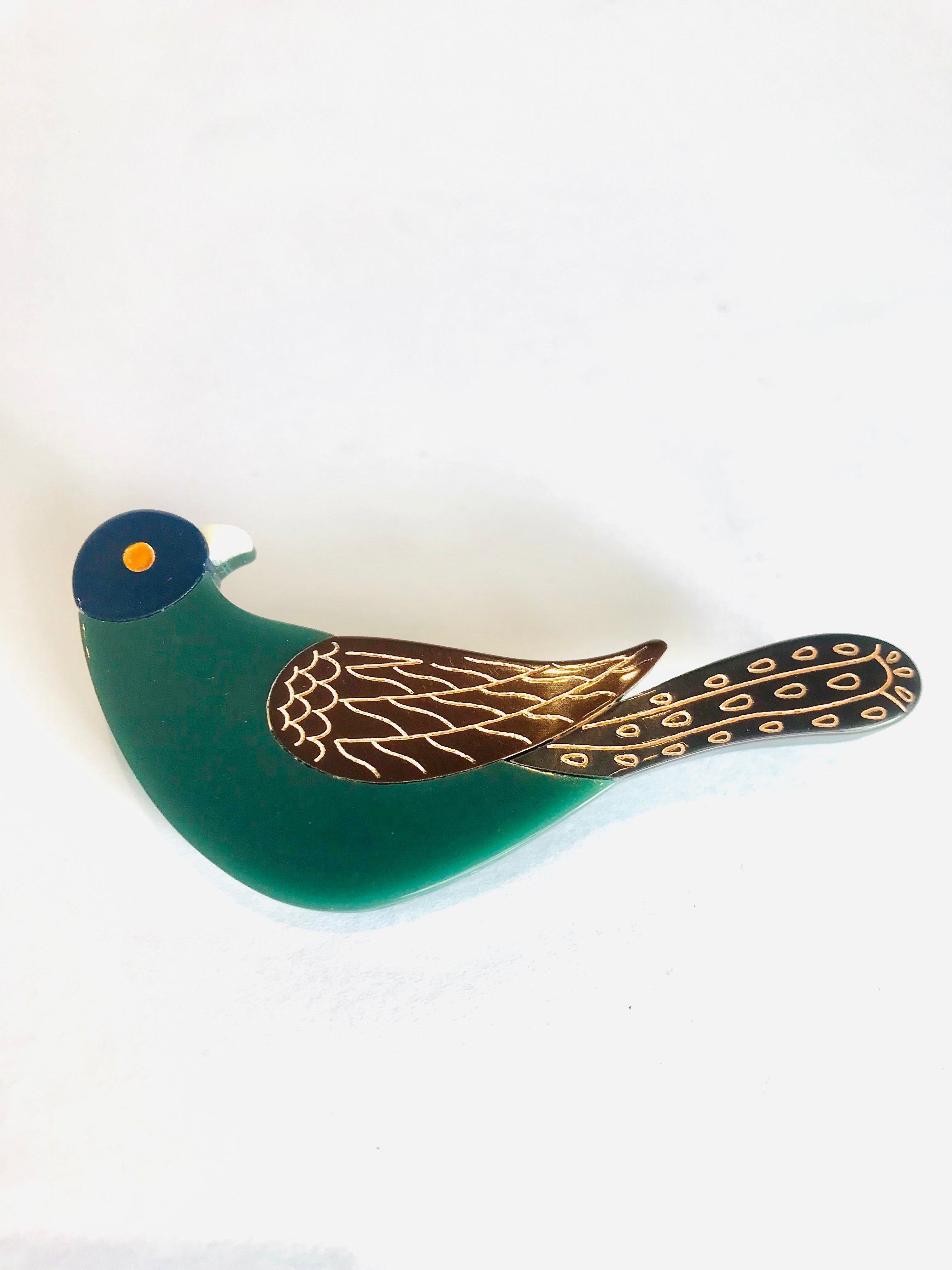 Sleek emerald green Olive Bird Brooch with navy head and gold wings
