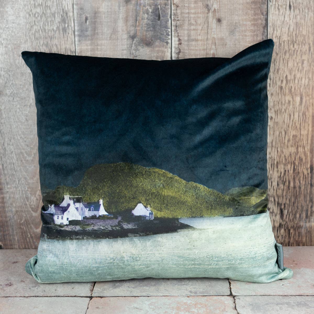 Dark teal Plockton velvet cushion with white cottages on green hills