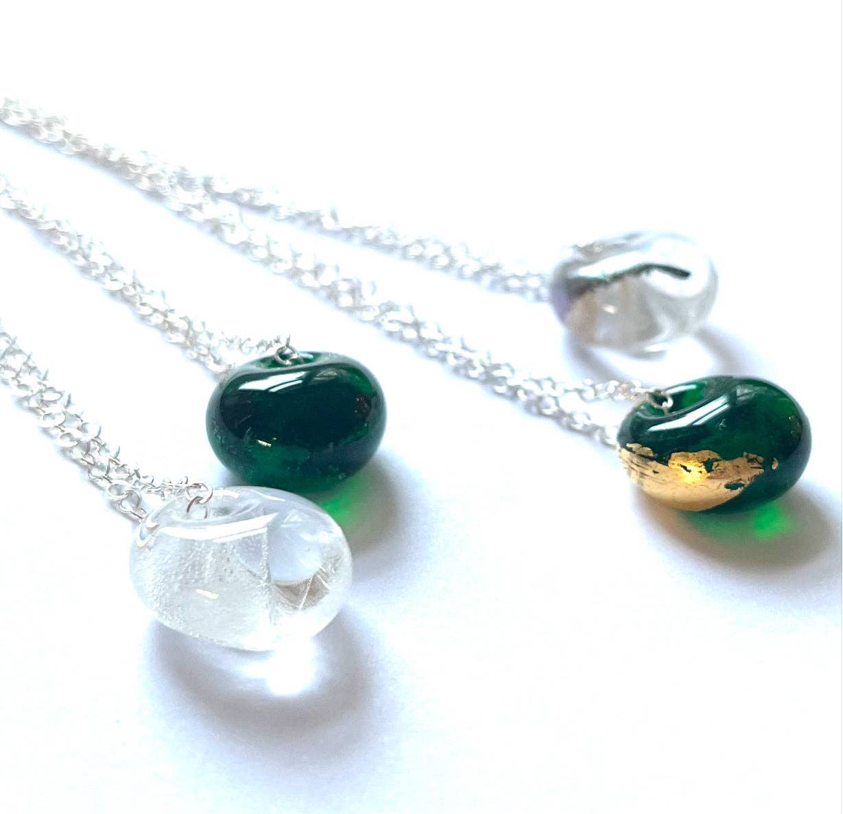 Elegant silver chain with emerald green whisky bottle pendant and gold leaf accents