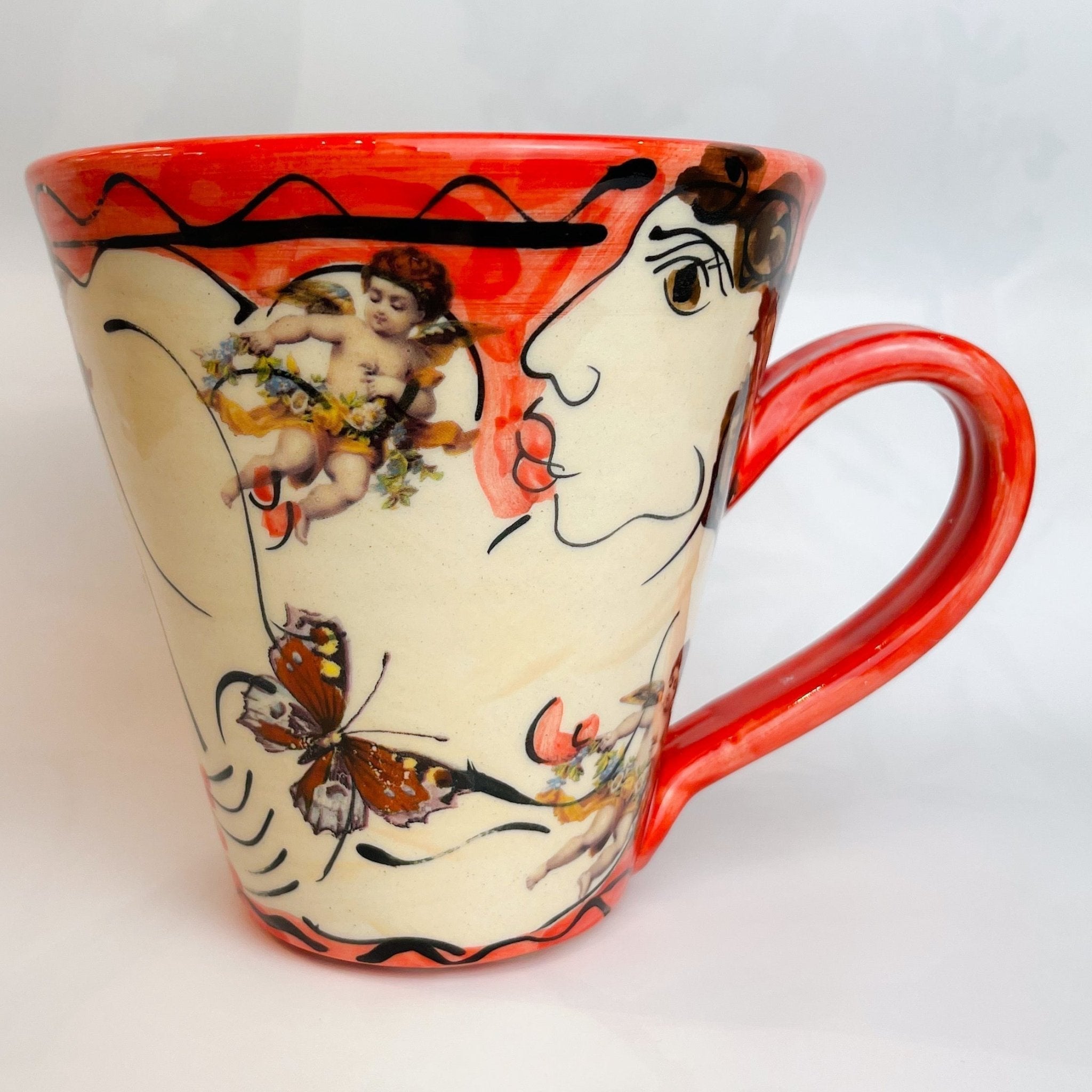 Vibrant red and cream ceramic Red Mug with hand-painted cherubs, butterflies, and stylized face
