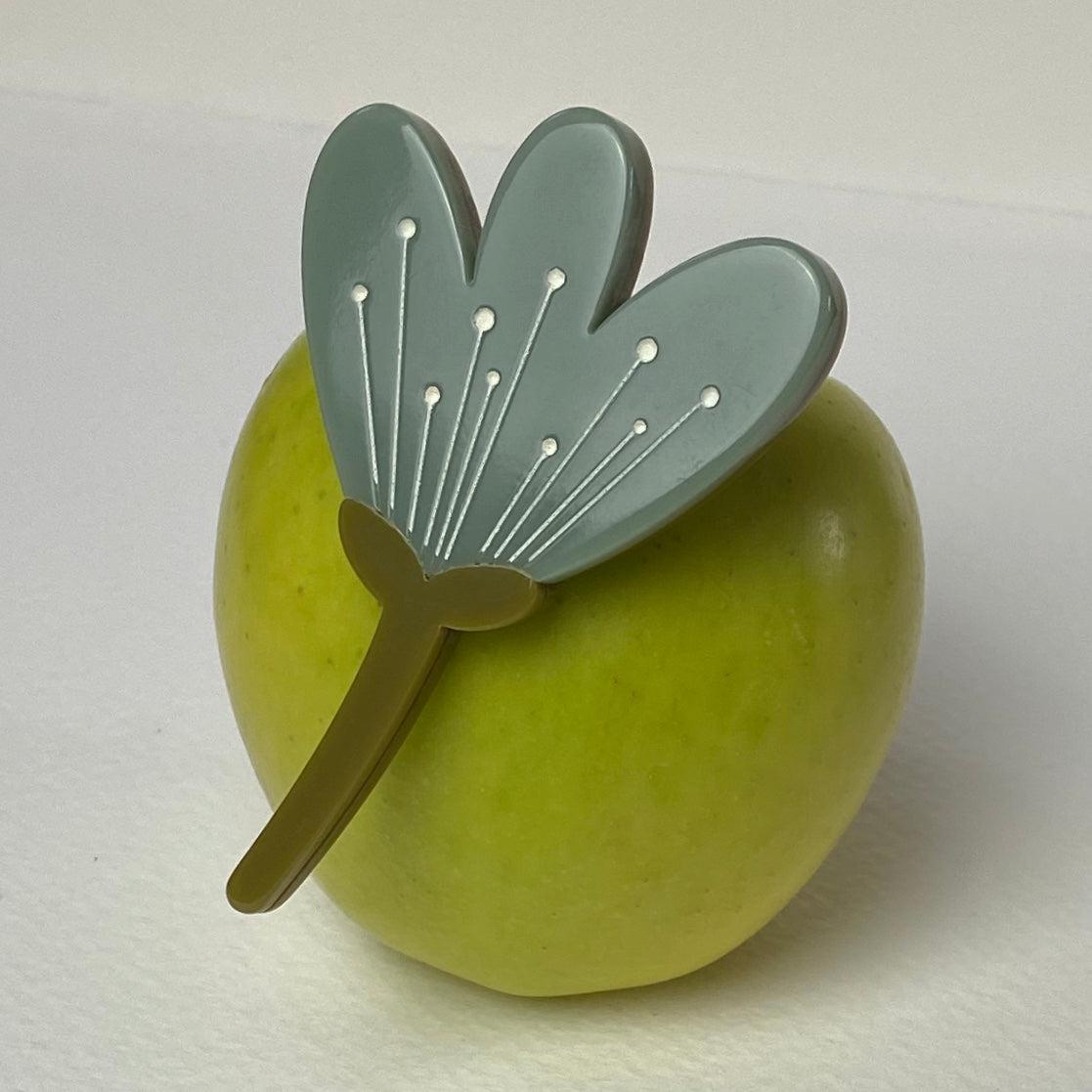 Sage Green Flower Brooch on vibrant green apple