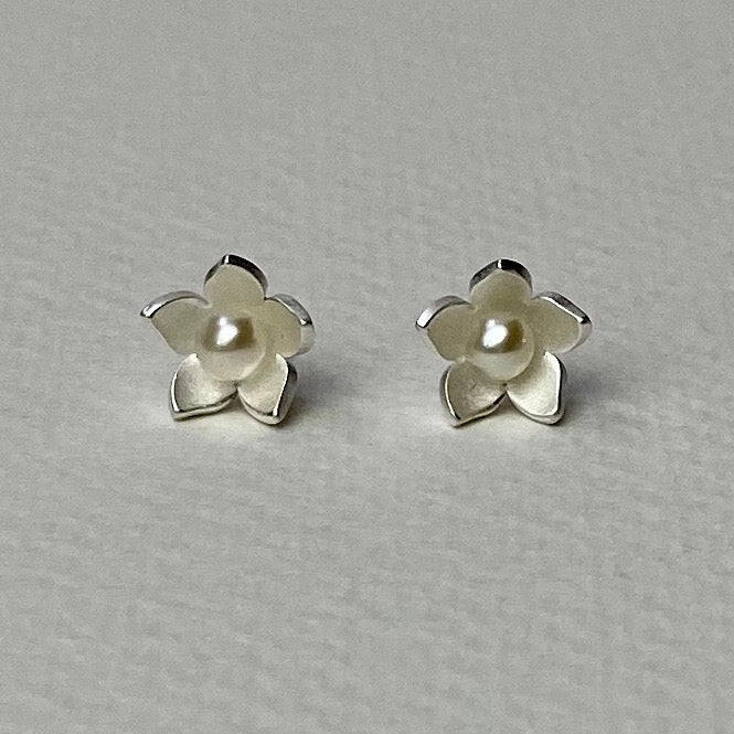 Satin silver flower-shaped stud earrings with central pearl