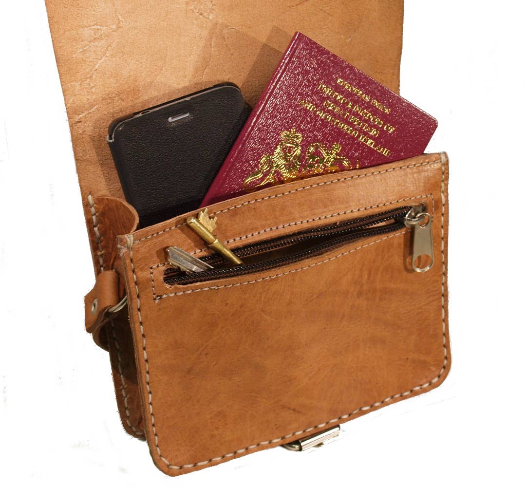 Dark brown small square leather saddle bag with tan wallet, keys, phone, maroon British passport