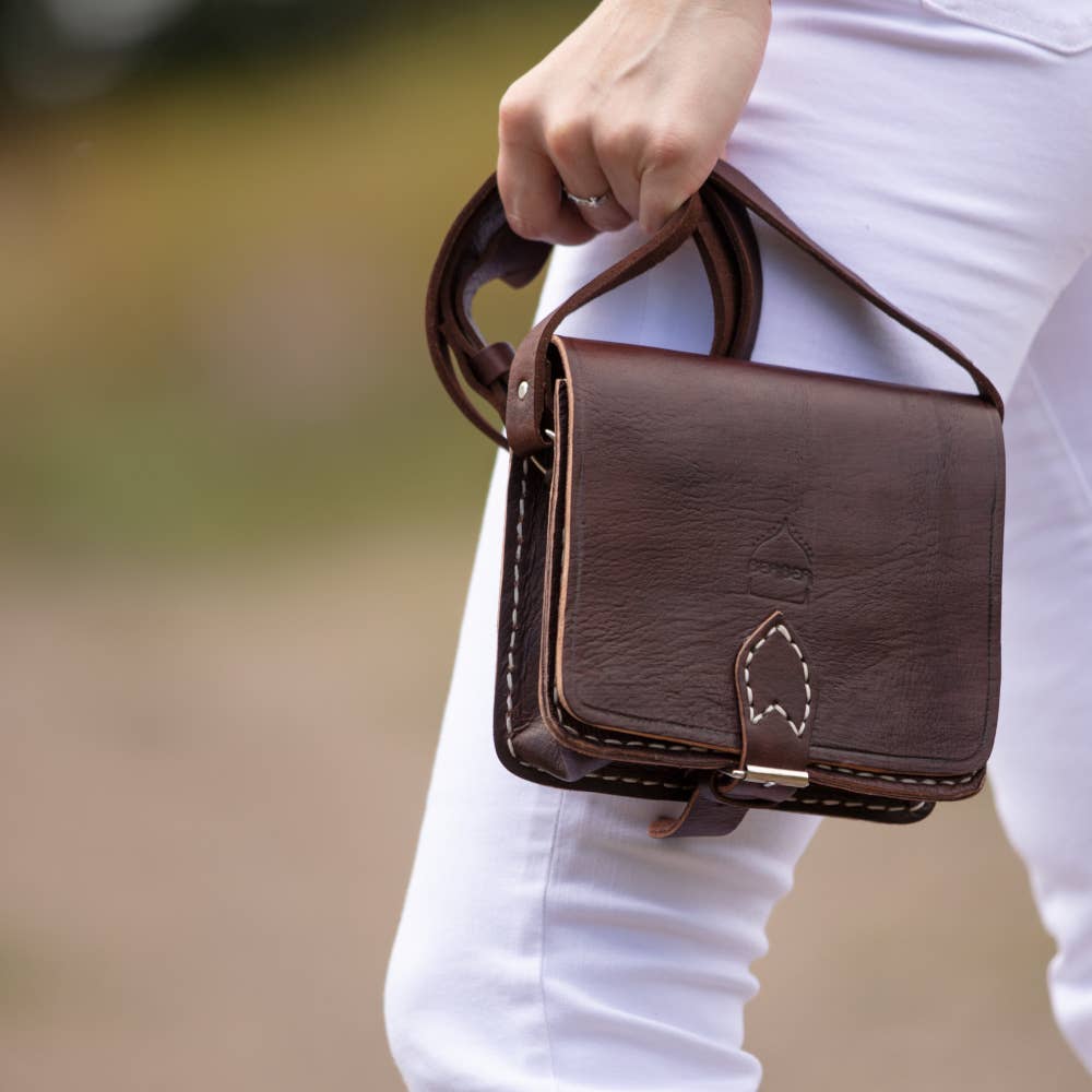 Dark brown small square leather saddle bag with leaf clasp and white stitching
