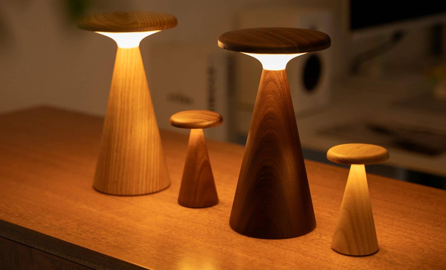 Three Sylva Large Walnut minimalist table lamps with warm glowing circular lights