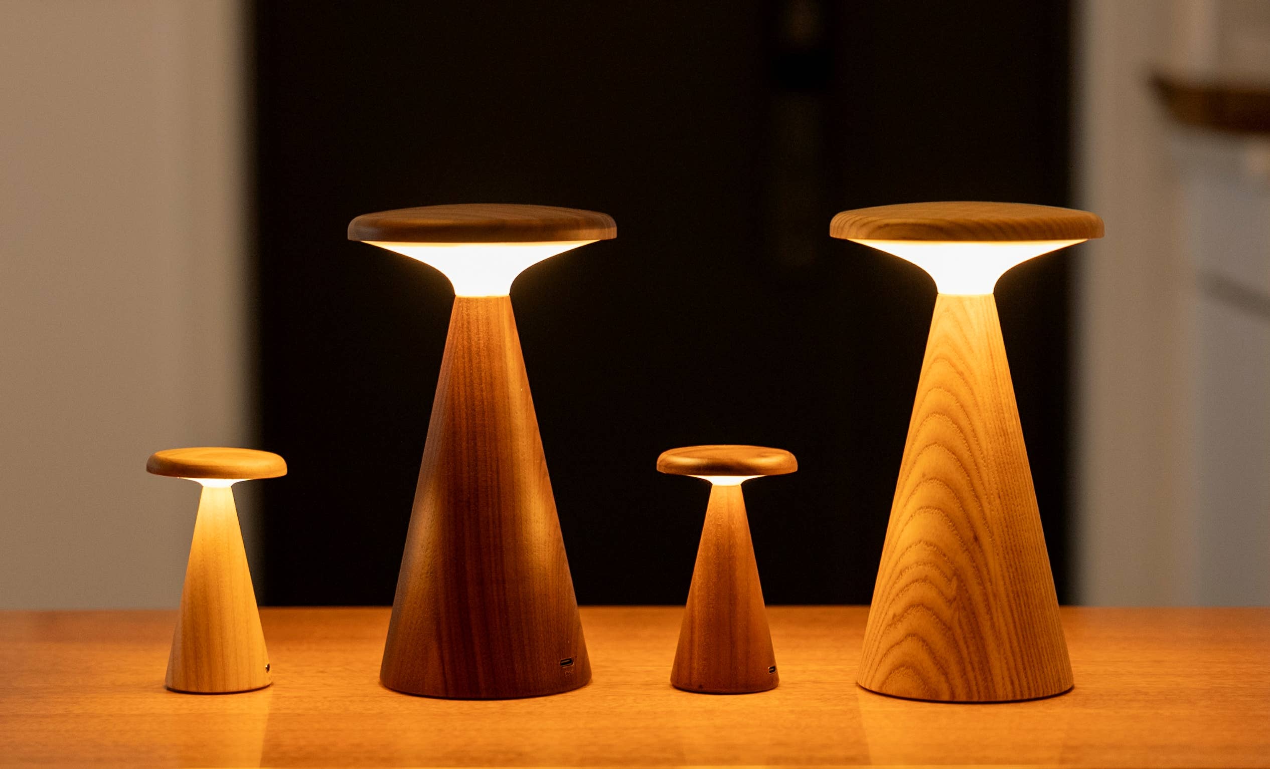 Set of four Sylva Large Walnut table lamps with warm glowing circular tops