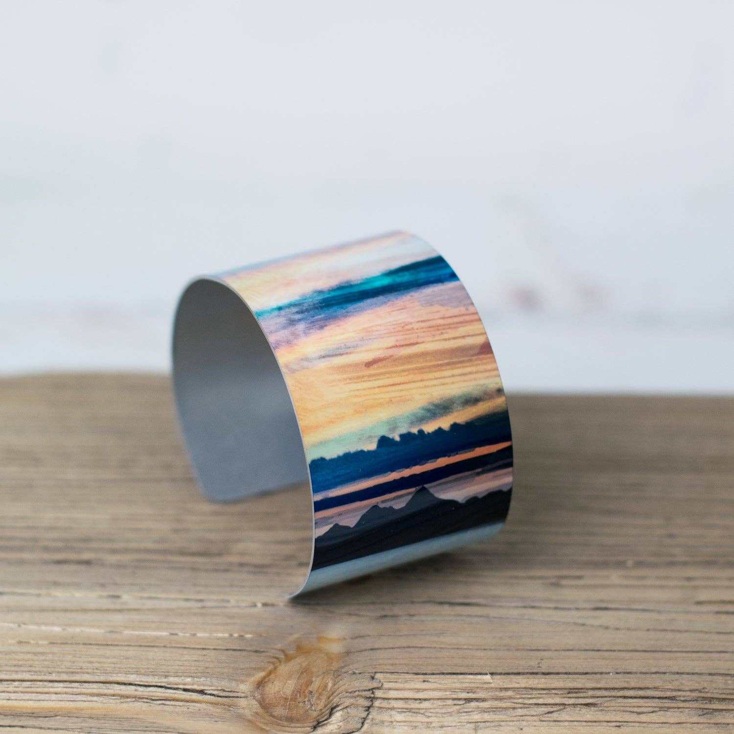 Western Isles aluminum bangle with teal orange blue landscape design